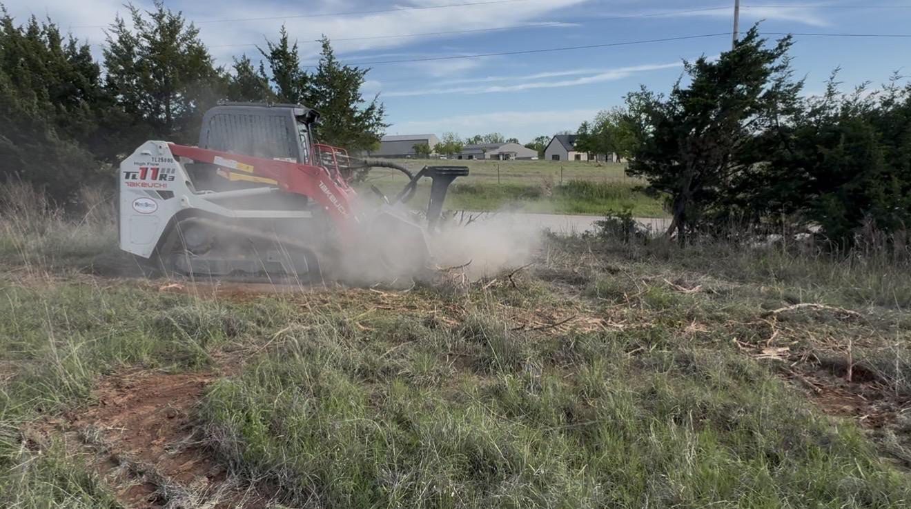 Forestry mulching results in Craig County, Oklahoma - skid steer kicking up dust while mulching cedar and brush on rural Oklahoma land